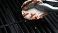 Butterflied pork chop removed with tongs from grill