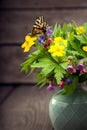 Butterfly and bouquet of field wild flowers in a vase on old boa Royalty Free Stock Photo