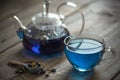 Butterfly pea blue tea in a glass cup on a wooden table, a teapot and dry leaves of clitoria trifoli Royalty Free Stock Photo