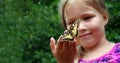 Butterfly sitting on the hand of a child. Child with a butterfly. Swallowtail butterfly on the hand of a little girl. Selective fo Royalty Free Stock Photo