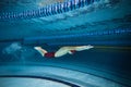 Butterfly swim style. Athletic young man, swimmer in motion training, preparing for competition, swimming in pool Royalty Free Stock Photo