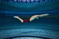 Butterfly swim style. Athletic young man, swimmer in motion training, preparing for competition, swimming in pool Royalty Free Stock Photo