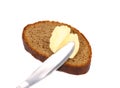Buttering knife on brown bread. Royalty Free Stock Photo