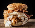 Buttermilk biscuit and fried chicken breast sandwich with a fried egg and bacon Royalty Free Stock Photo