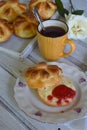 Buttermilk dinner buns in flower form served with butter, knife, glass of milk and jam on wooden background. Fresh baked brioche. Royalty Free Stock Photo