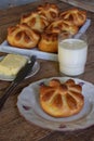 Buttermilk dinner buns in flower form served with butter, knife, glass of milk on wooden background. Fresh baked brioche. Homemade Royalty Free Stock Photo