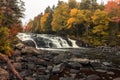 Buttermilk Falls in Long Lake, NY, Adirondacks, surrounded by vivid fall foliage on an overcast afternoon Royalty Free Stock Photo