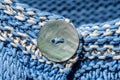 A button on a blue knitted sweater Royalty Free Stock Photo