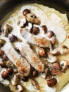 Button mushrooms sliced in a pan with cream and meat Royalty Free Stock Photo