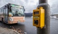 The button for pedestrians on a pole near the crosswalk with a bus in a background Royalty Free Stock Photo