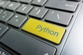 button with the python on the yellow keyboard of modern laptop