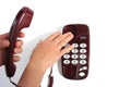 Female hands hold the telephone receiver and press the button