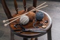 Button, scissors and yarn ball on wooden chair