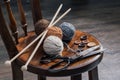 Button, scissors and yarn ball on wooden chair