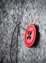 Button on thick coat fabric and thread with needle on it Royalty Free Stock Photo