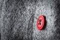 Button on thick coat fabric and thread with needle on it Royalty Free Stock Photo