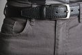 Buttoned black, male leather belt worn on jeans. Royalty Free Stock Photo