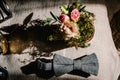 Buttonhole, Boutonniere for the groom, stylish men`s gray bow tie. Wedding accessories on rustic brown background. traditional