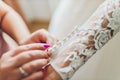 Buttoning the dress on bride. Details of beautiful lace wedding dress. Royalty Free Stock Photo