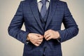 Buttoning up male vested blue suit with tie in formal fashion style grey background, formalwear