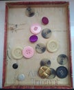 Buttons in a decorative box, an assortment of small fasteners.