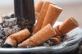 Butts of cigarettes in full ashtray Royalty Free Stock Photo