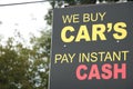 we buy cars pay instant cash sign with tree and sky behind, yellow and red Royalty Free Stock Photo