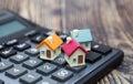 Buy home. House is placed on the calculator. Planning savings money of coins to buy a home concept for property, mortgage and real Royalty Free Stock Photo