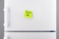 Buy milk and eggs note on green paper on refrigerator