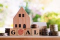 Buy new home concept with goal word on wooden house model with money, future plan for real estate Royalty Free Stock Photo