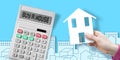 Buy a new house or apartment - concept image with a calculator with BUY A HOUSE text against a city skyline