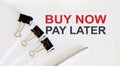 BUY NOW PAY LATER written on white page with office tools