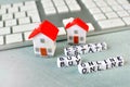 Buy real estate online concept with miniature house, computer keyboard and cubes with letters. Royalty Free Stock Photo