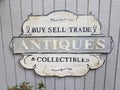 Buy sell trade antiques collectibles sign on grey wall Royalty Free Stock Photo