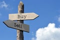 Buy or sell - wooden signpost with two arrows Royalty Free Stock Photo