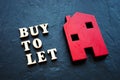 Buy to let and red home on the stone. Royalty Free Stock Photo