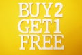 Buy Two Get One Free Sale Promotion on Yellow background Royalty Free Stock Photo