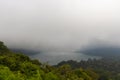 Buyan Lake encompassed by dense forest, in fog and clouds, Bali Royalty Free Stock Photo