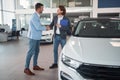 Buyer shaking hand with salesman in car sales salon