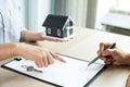 Buyer hand signs contract after Real estate agents explains a business contract, lease, purchase, mortgage, loan, or home