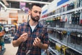 a buyer in a hardware store in the equipment department for a drill and a screwdriver chooses drills Royalty Free Stock Photo