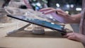 Buyers hands in the electronics store chooses a modern new gadge on blurred background, close-up