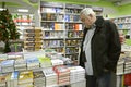 Buyer standing in front of a pile of fiction books bying, bookshop. Kyiv, Ukraine