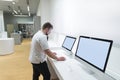 Buyer uses a monoblock computer in a modern technology store. man with a beard chooses a computer at an store