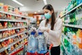 Buyer wearing a protective mask.Shopping during the pandemic.Emergency to buy list.Water supplies shortage.Panic buying during