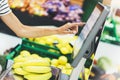 The buyer weighs the yellow bananas and points the fingers on the screen electronic scales, woman shopping healthy food in super Royalty Free Stock Photo