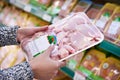 Buyer woman chooses chicken meat in shop