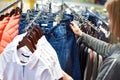 Buyer woman chooses jeans clothes in store