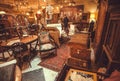 Buyers inside the antique shop with utensils, lamps, souvenirs and retro furniture