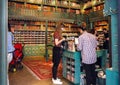 Buyers and racks of canned seafood inside colorful local shop with tins of sea fish